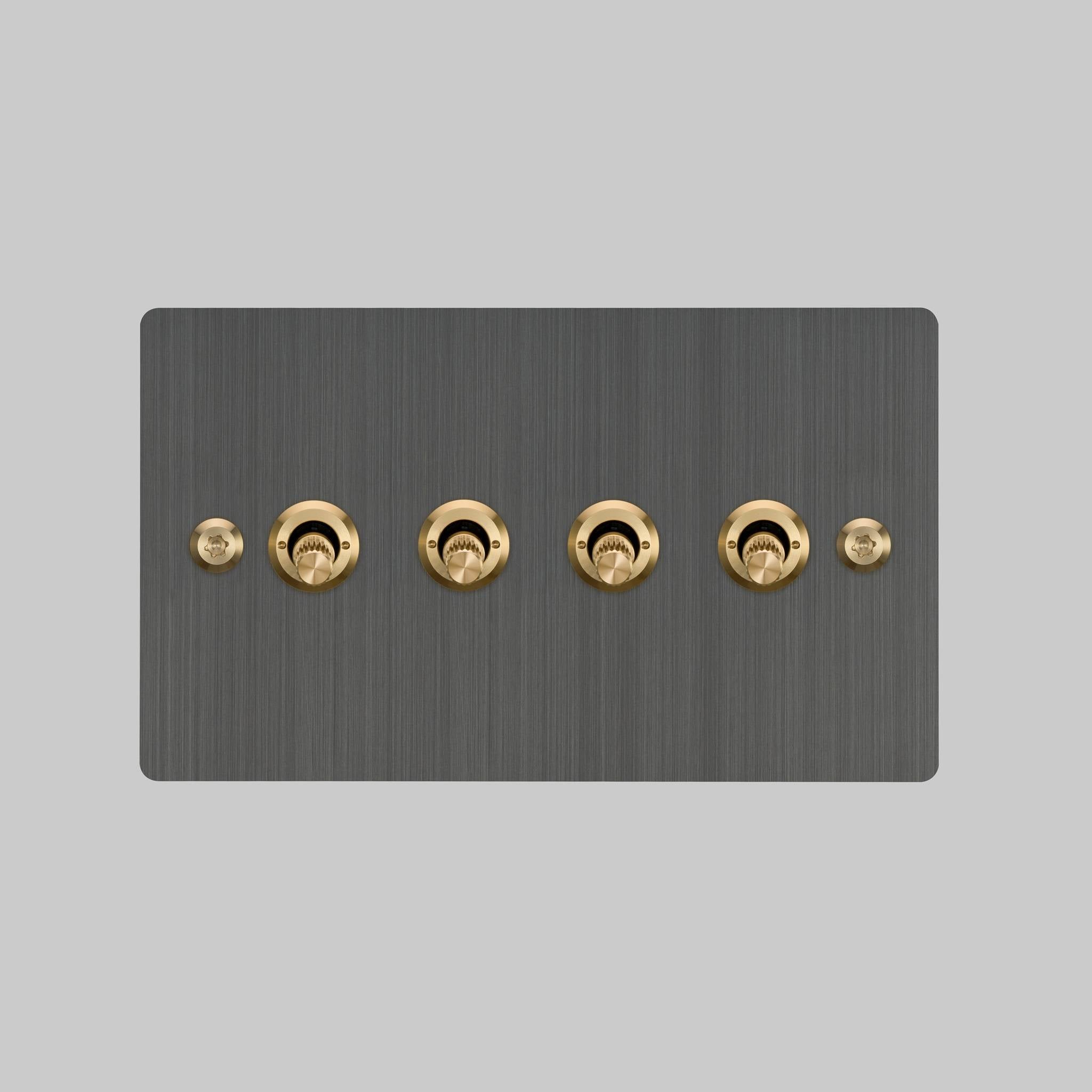 Buster + Punch 4G toggle switch, smoked bronze plate with brass linear knurl toggle arms, elevated angle view