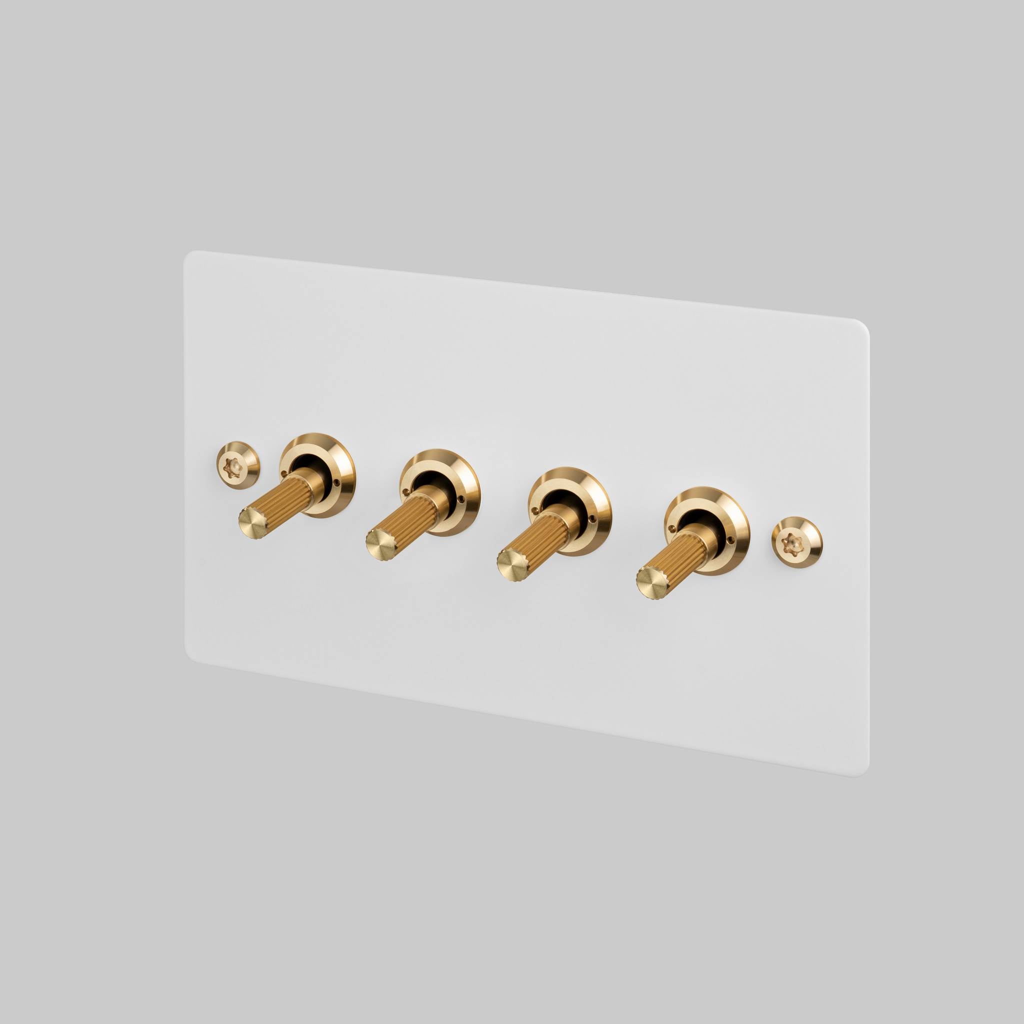 Buster + Punch 4G toggle switch, white plate with brass linear knurl toggle arms, front view