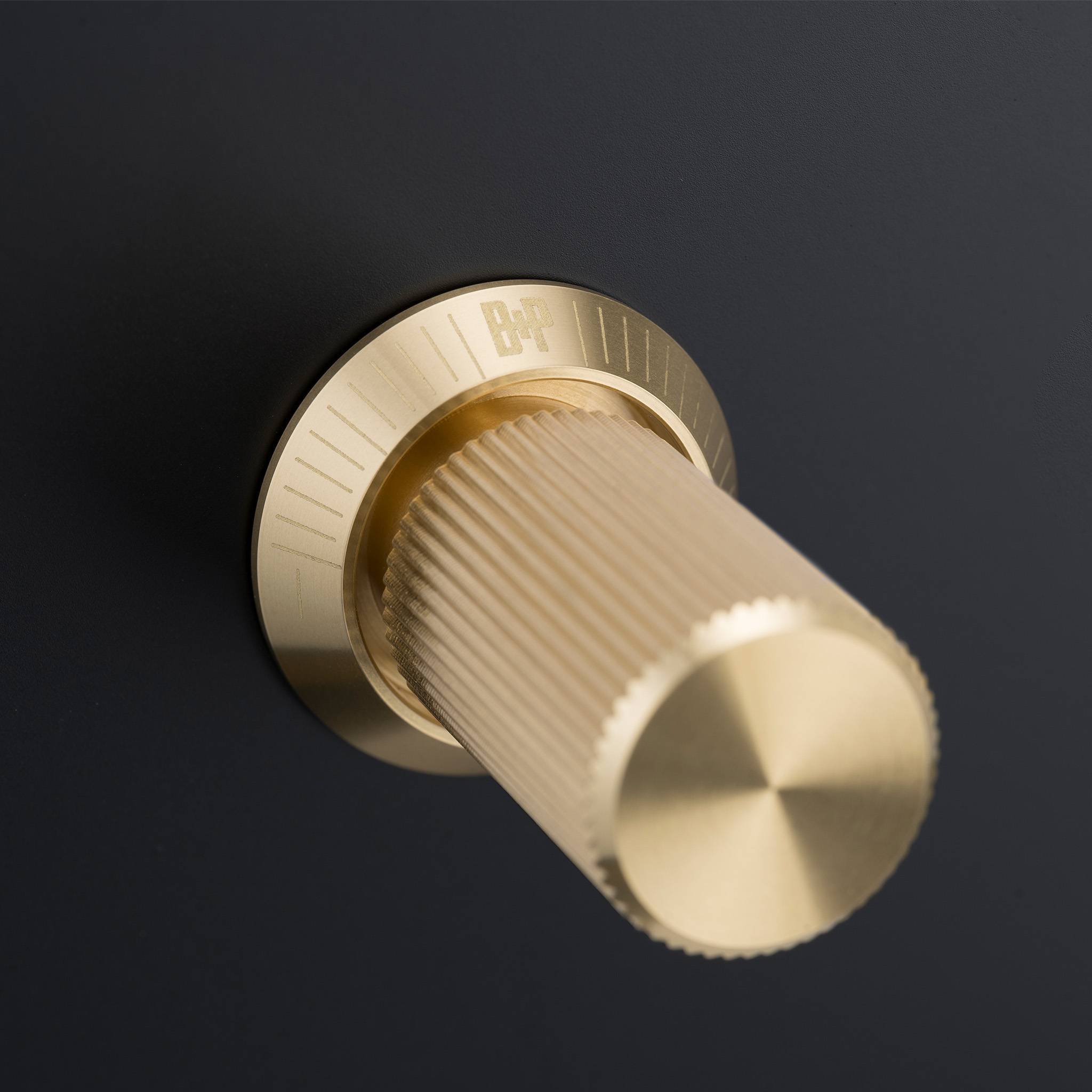 Buster + Punch 4G dimmer switch, Black plate with Brass linear knurl dimmer knob, close up of the knurl detail
