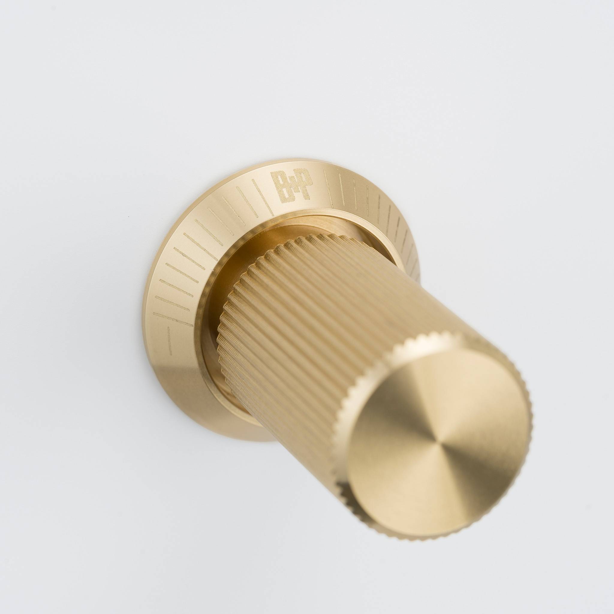 Buster + Punch 2G dimmer switch, white plate with brass linear knurl knob, close up of the knob detail