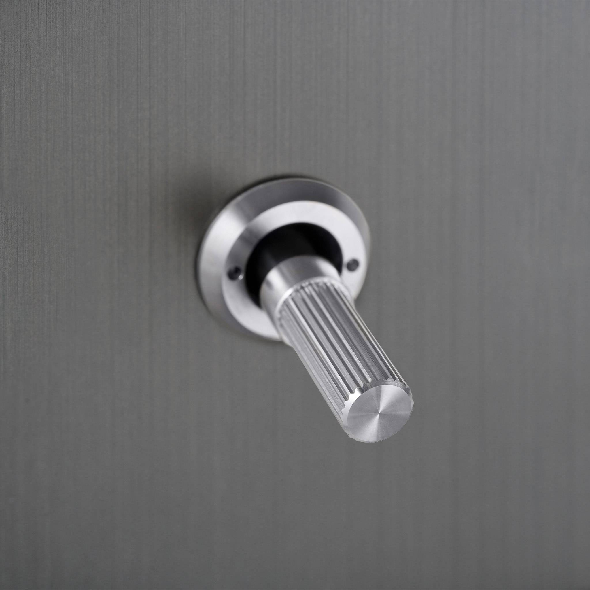 Buster + Punch 2G 2-way toggle switch, smoked bronze plate with steel linear knurl toggle arm, close up of the toggle arm detail