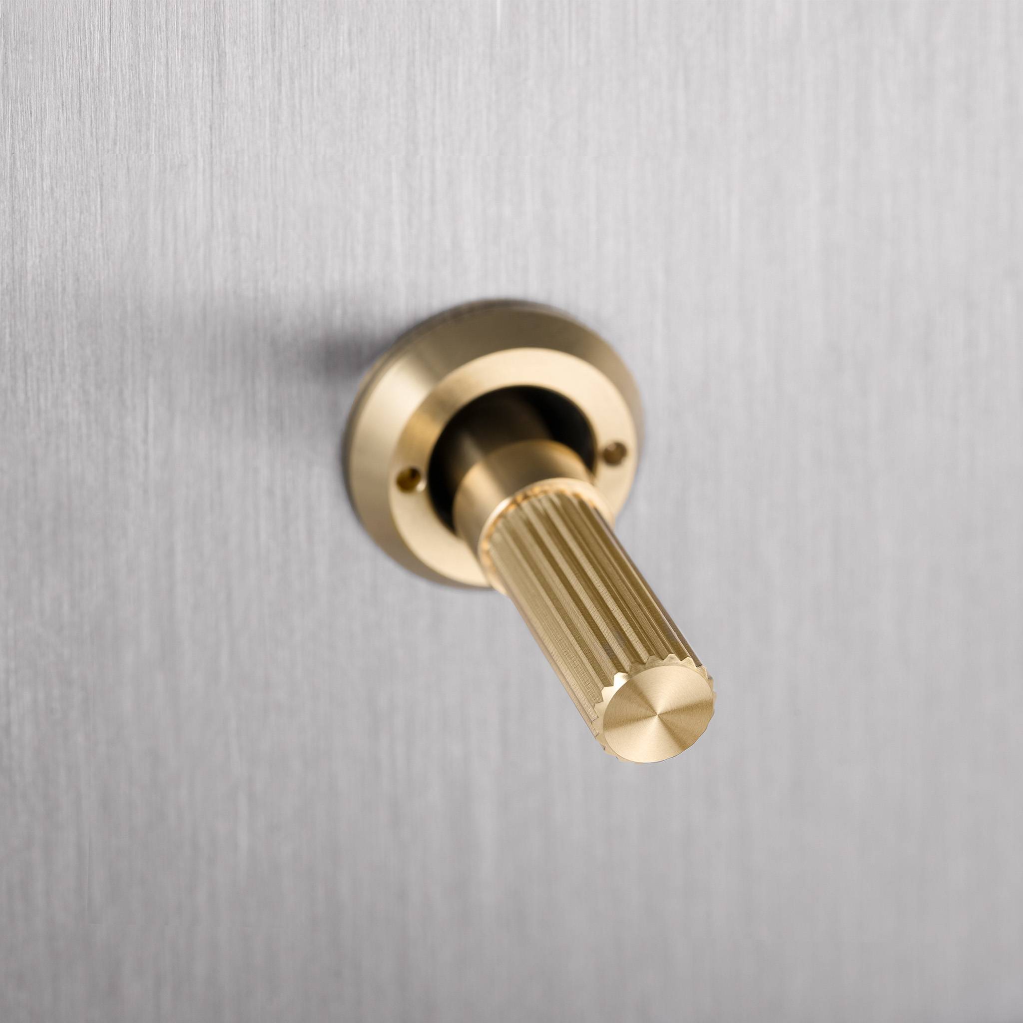 Buster + Punch 4G toggle switch, steel plate with brass linear knurl toggle arms, close up of the knurl detail